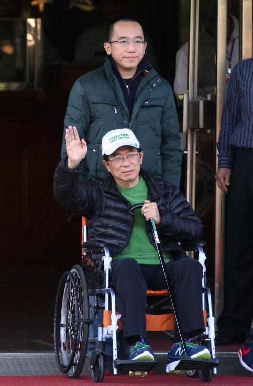 Former Taiwan president Chen Shui-bian waves to supporters as he is escorted by his son Chen Chih-chung after being freed from prison in Taichung on January 5, 2015