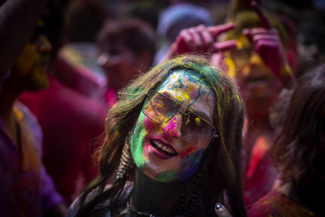 A girl smeared with colors celebrates Holi, the festival of colors on a street in Guwahati, India, Wednesday, March 8, 2023.Millions of Indians on Wednesday celebrated the ''Holi" festival, dancing to the beat of drums and smearing each other with green, yellow and red colors and exchanging sweets in homes, parks and streets. Free from mask and other COVID-19 restrictions after two years, they also drenched each other with colored water. (AP Photo/Anupam Nath)