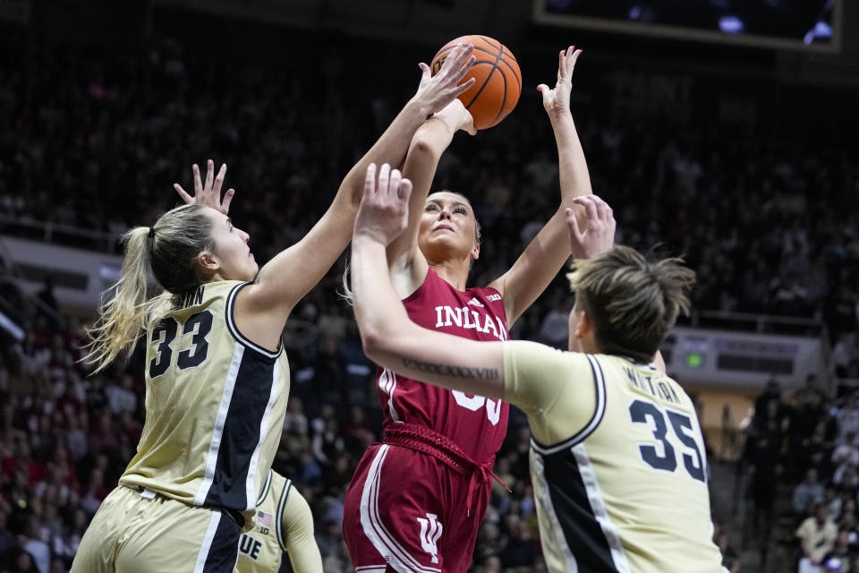 Indiana guard Sydney Parrish (33) shoots between Purdue guard Madison Layden (33) and forward Rickie Woltman (35) in the first half of an NCAA college basketball game in West Lafayette, Ind., Sunday, Feb. 5, 2023. (AP Photo/Michael Conroy)