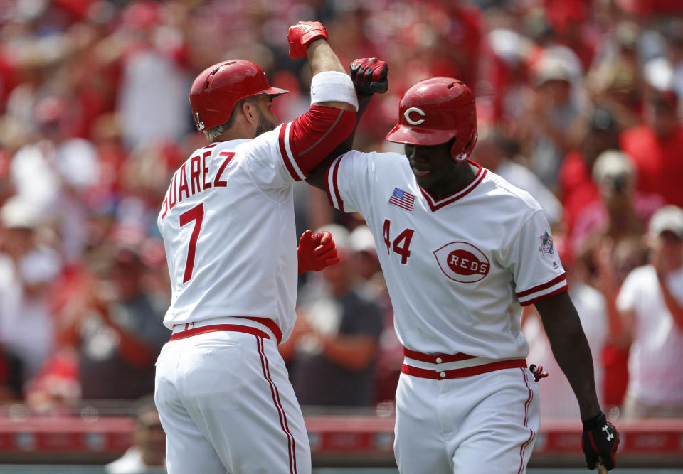 Cincinnati Reds' Eugenio Suarez (7) is congratulated by Aristides Aquino (44) on a solo home run off St. Louis Cardinals starting pitcher Jack Flaherty during the first inning of a baseball game, Sunday, Aug. 18, 2019, in Cincinnati. (AP Photo/Gary Landers)