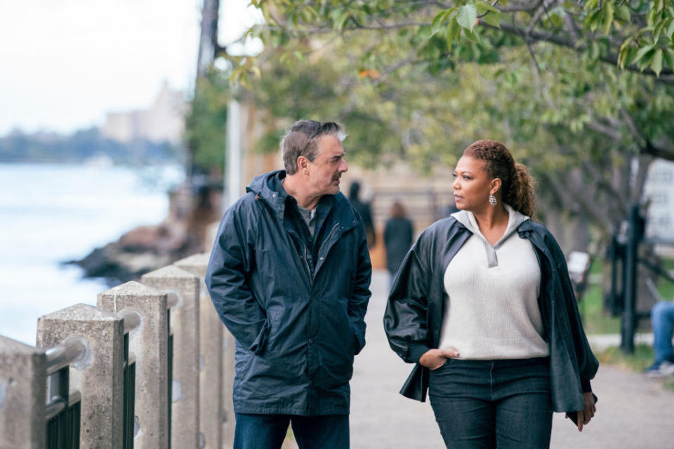 Chris Noth and Queen Latifah walking down a pathway by a waterfront in a scene from the show