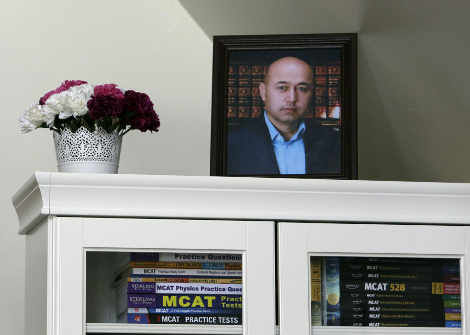 A portrait of Yalqun Rozi is seen atop a bookcase in his son and wife's apartment Thursday, April 18, 2019, in Philadelphia. For fifteen years, the literary critic had skillfully navigated state bureaucracies to publish textbooks that taught classic poems and folk tales to millions of his Turkic Uighur minority people in China’s far western region of Xinjiang. (AP Photo/Jacqueline Larma)