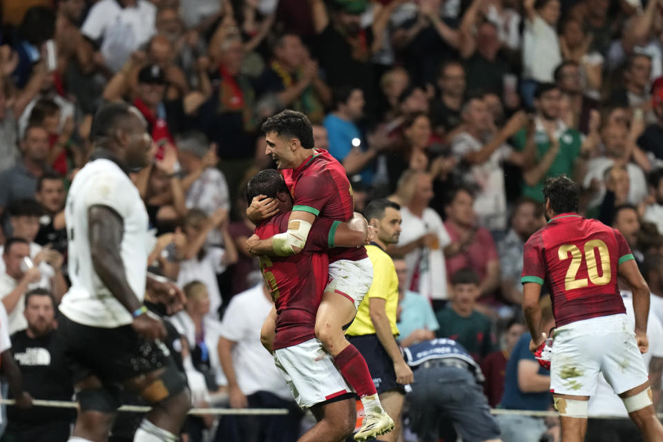 Portugal's Raffaele Storti celebrates with teammate at the end of Rugby World Cup Pool C match between Fiji and Portugal, at the Stadium de Toulouse in Toulouse, France, Sunday, Oct. 8, 2023. (AP Photo/Pavel Golovkin)