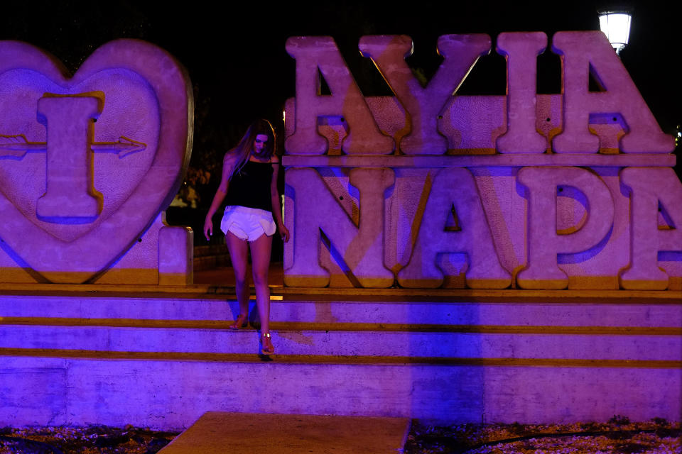 A tourist walks at a sculpture that read "I Love Ayia Napa" after posing for photos in the southeast resort of Ayia Napa in the eastern Mediterranean island of Cyprus late Wednesday, July 17, 2019. A Cyprus police official says 12 Israelis have been detained after a 19-year-old British woman alleged that she was raped in the resort town of Ayia Napa. (AP Photo/Petros Karadjias)