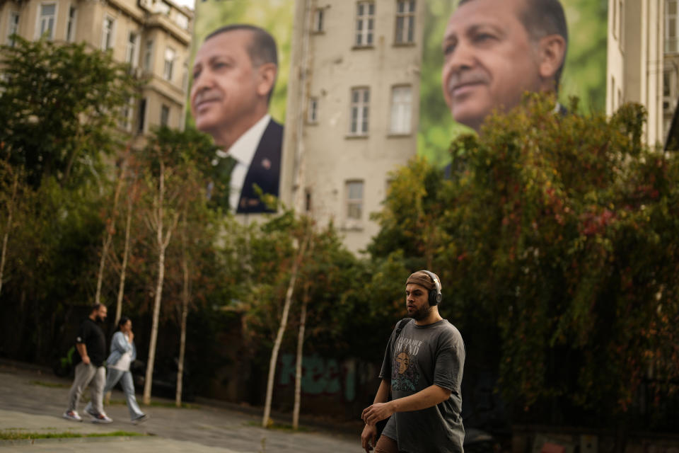 A man past by a poster of Turkish President Recep Tayyip Erdogan, in Istanbul, Turkey, Wednesday, Oct. 25, 2023. The Turkish Republic, founded from the ruins of the Ottoman Empire by the national independence hero Mustafa Kemal Ataturk, turns 100 on Oct. 29. Ataturk established a Western-facing secular republic modeled on the great powers of the time, ushering in radical reforms that abolished the caliphate, replaced the Arabic script with the Roman alphabet, gave women the vote and adopted European laws and codes. (AP Photo/Emrah Gurel)