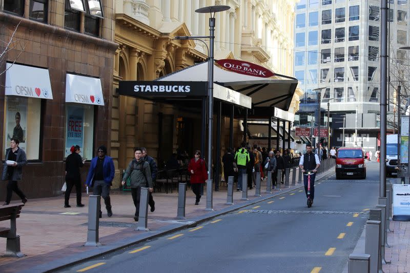 People walk outside a Starbucks cafe on Lambton Quay street in Wellington, New Zealand