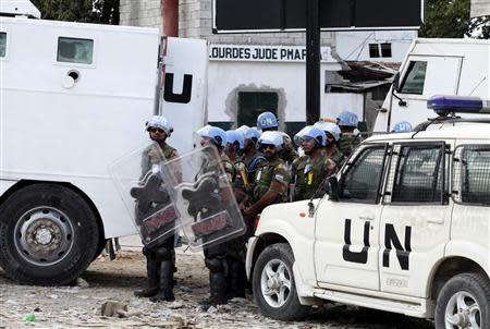 U.N. peacekeepers stand on the side of a road during protests in Port-au-Prince November 18, 2013. Thousands of Haitians took to the streets on Monday calling for President Michel Martelly to resign, and some protesters scuffled with police as international concern mounts over rising violence in the impoverished Caribbean nation. REUTERS/Marie Arago