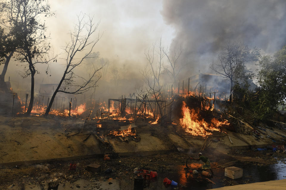 Rohingya refugees try to salvage their belongings after a major fire in their Balukhali camp at Ukhiya in Cox's Bazar district, Bangladesh, Sunday, March 5, 2023. A massive fire raced through a crammed camp of Rohingya refugees in southern Bangladesh on Sunday, leaving thousands homeless, a fire official and the United Nations said. (AP Photo/Mahmud Hossain Opu)