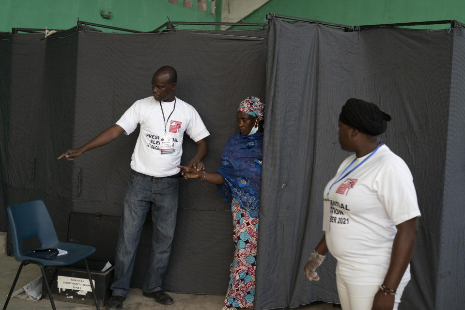 A woman leaves the polling station after voting in Gambia's presidential elections in Bakau, Gambia, Saturday, Dec. 4, 2021. Gambians vote in a historic election that will for the first time not have former dictator Yahya Jammeh, who ruled for 22 years, on the ballot. (AP Photo/Leo Correa)