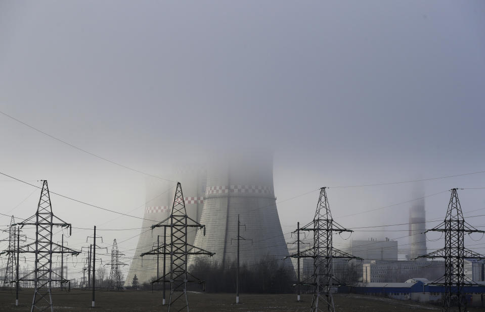 FILE - In this Thursday, Dec. 6, 2018 file photo a power plant is partially obscured by fog in Minsk, Belarus. As politicians haggle at a U.N. climate conference in Poland over ways to limit global warming, the industries and machines powering our modern world keep spewing their pollution into the air and water. The fossil fuels extracted from beneath the earth’s crust _ coal, oil and gas _ are transformed into the carbon dioxide that is now heating the earth faster than scientists had expected even a few years ago. (AP Photo/Sergei Grits, File)