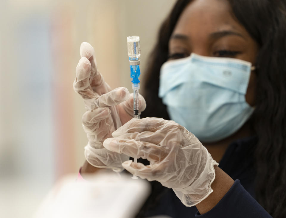 A health worker loads syringes with the vaccine on the first day of the Johnson and Johnson vaccine being made available to residents at the Baldwin Hills Crenshaw Plaza in Los Angeles Thursday, March 11, 2021. The California Department of Public Health (CDPH) is highlighting the new the one-dose Janssen COVID-19 vaccine by Johnson & Johnson. (AP Photo/Damian Dovarganes)