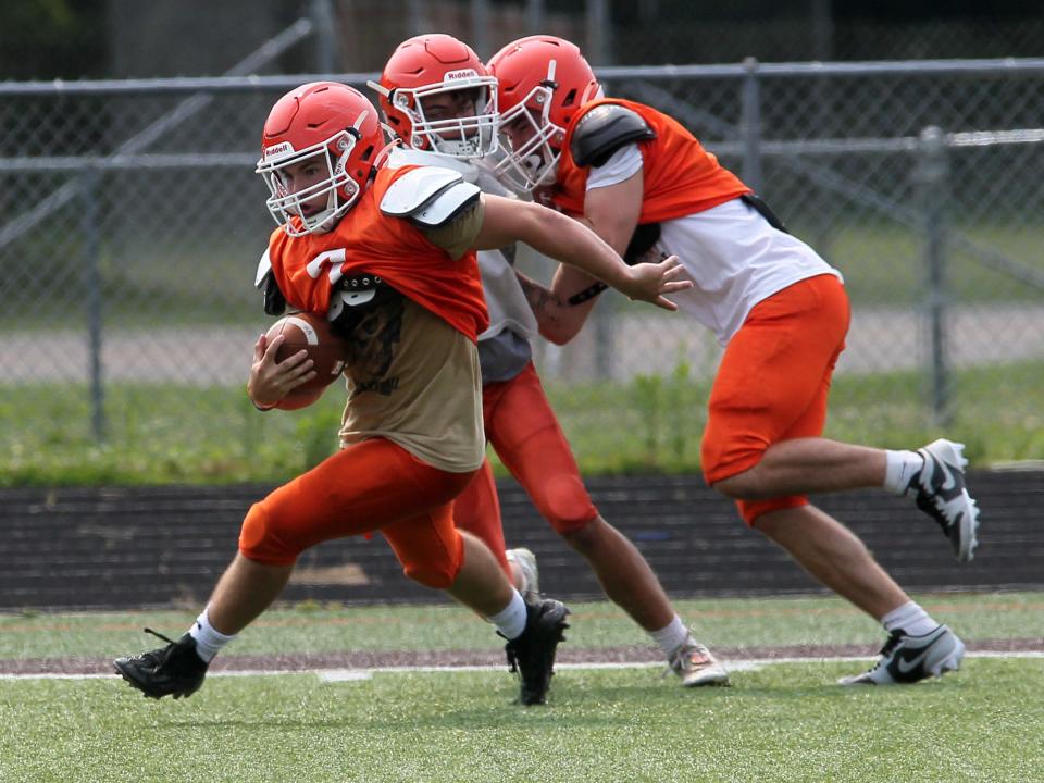 Heath's Connor Corbett turns upfield past a block during practice at Swank Field on Tuesday, Aug. 1, 2023.