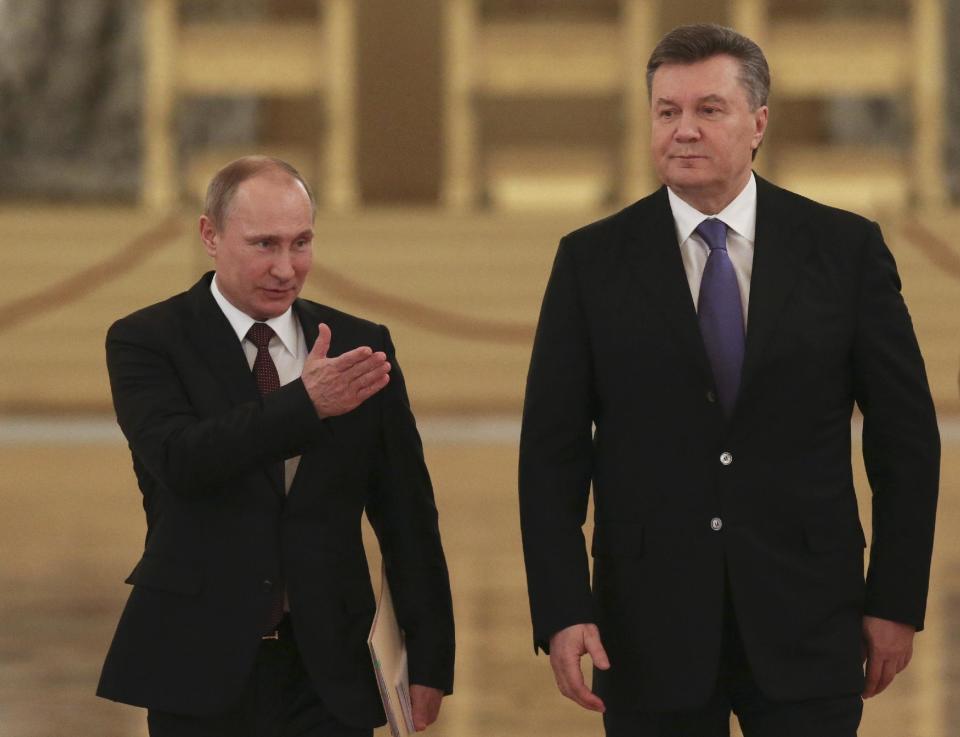 FILE - In this Tuesday, Dec. 17, 2013 file photo Russian President Vladimir Putin, left, shows the way to his Ukrainian counterpart Viktor Yanukovych during a meeting in the Kremlin in Moscow, Russia. Moscow on Wednesday granted Ukrainian President Viktor Yanukovych protection "on the territory of Russia," shortly after the fugitive leader sought help from the Kremlin, according to an official quoted by Russian news agencies. (AP Photo/Sergei Karpukhin, Pool, file)