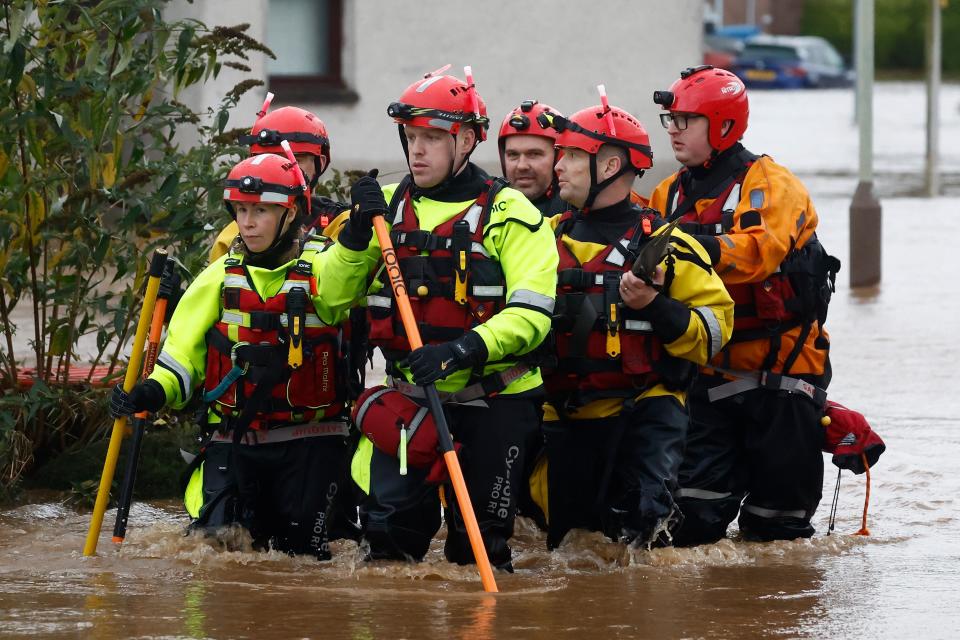 Members of a rescue team wade through the flood waters in Brechin after hundreds of homes were evacuated (Getty Images)