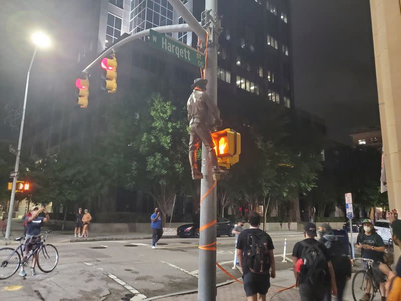 A Confederate statue is seen hanging on a street post in Raleigh