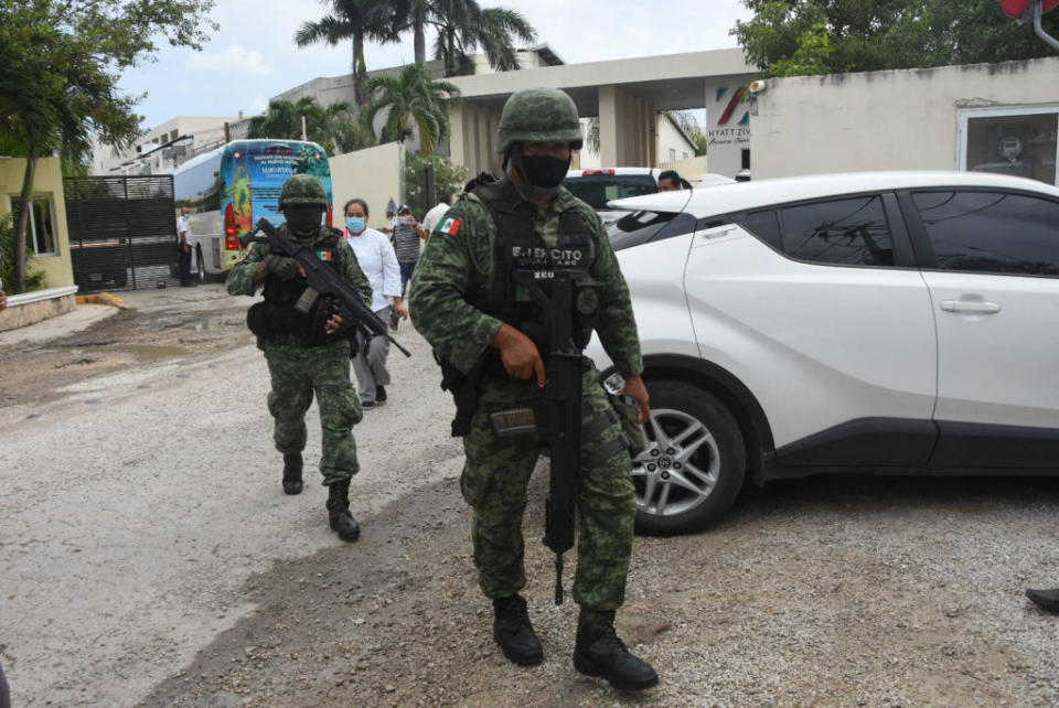 Mexican soldiers walk outside the Hyatt Ziva Riviera hotel in Puerto Morelos, Quintana Roo state, Mexico, after a shooting. 