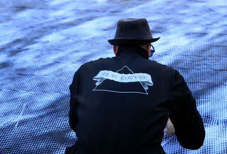 French artist JR works in the courtyard of the Louvre Museum near the glass pyramid designed by Ieoh Ming Pei as the Louvre Museum celebrates the 30th anniversary of its glass pyramid in Paris, France, March 26, 2019. REUTERS/GonzaloÊFuentes