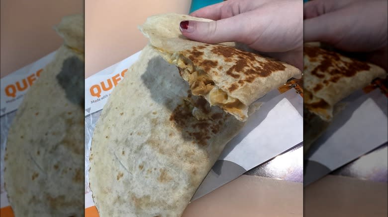 Perason holding taco bell quesadilla