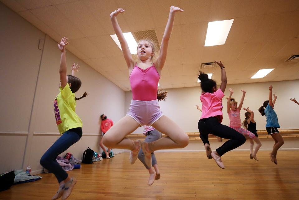 Ahbry-Elle Willams, 8, and the rest of the intermediate ballet class work on their jumps at the Judy Dollenmayer Studio of Dance in Gahanna on March 24. The day's theme was "neon day" as part of the studio's spirit week.