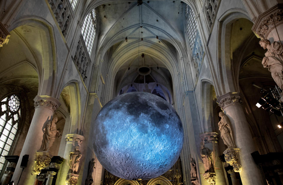 FILE - The Museum of the Moon art installation by artist Luke Jerram at the St. Rombouts Cathedral in Mechelen, Belgium, Dec. 14, 2019. Across Europe, the continent that nurtured Christianity for most of two millennia, many churches, convents, beguinages and chapels stand empty as faith and church attendance have dwindled over the past half century. Many are now been repurposed to preserve their historical and architectural relevance, while others have opened up to non-religious activities to expand their use. (AP Photo/Virginia Mayo, File)