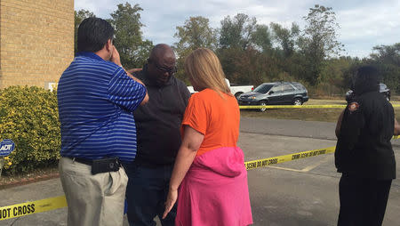 People gather in front of Hopewell Baptist Church that was damaged by fire and graffiti in Greenville, Mississippi, U.S., November 2, 2016. Courtesy Angie Quezada/Delta Daily News via REUTERS