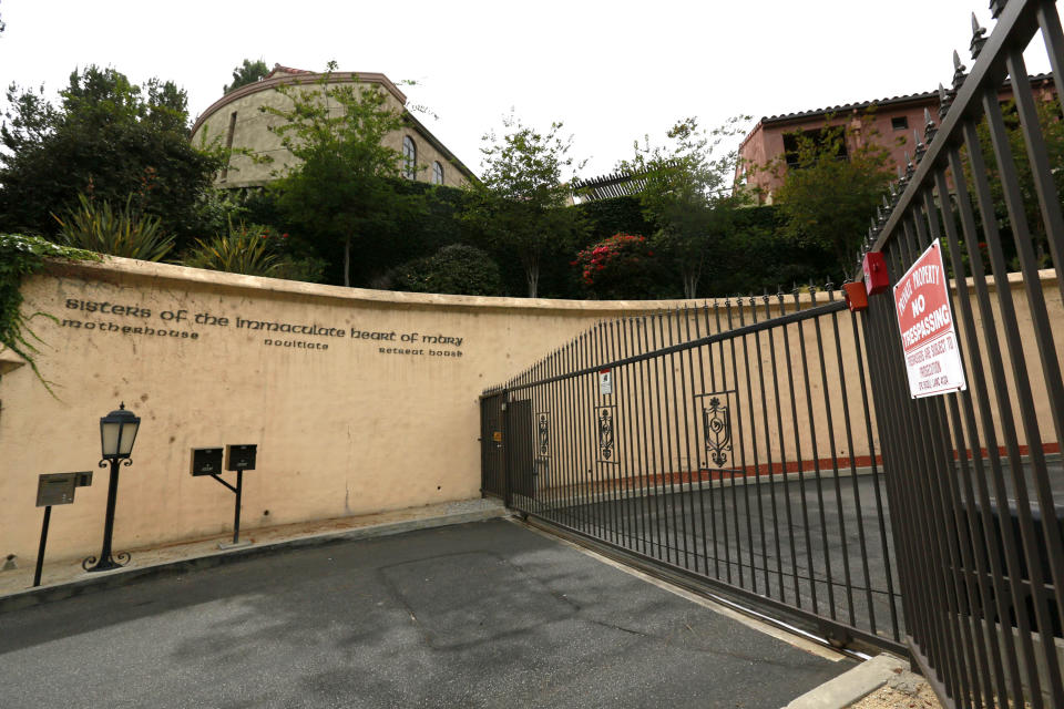 Gate entrance with sign on wall reading: Sister of the Immaculate Heart of Mary, mother house, novitiate, retreat house.