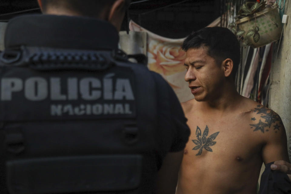 Un agente de policía interroga a un hombre en un operativo para buscar armas y drogas con el fin de combatir a grupos criminales y extorsionadores, el jueves 4 de abril de 2024, en Guayaquil, Ecuador. (AP Foto/César Muñoz)
