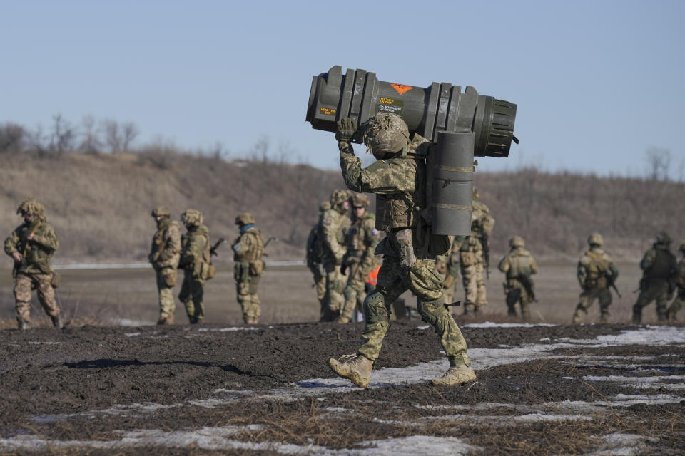 FILE - A Ukrainian serviceman carries an NLAW anti-tank weapon during an exercise in the Joint Forces Operation, in the Donetsk region, eastern Ukraine, Feb. 15, 2022. As the U.S. and other NATO members warn of the potential for a devastating war, Russia is not countering with bombs or olive branches -- but with sarcasm. (AP Photo/Vadim Ghirda, File)