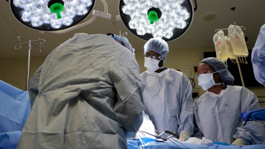 Meharry Medical College students Emmanuel Kotey (center) and Teresa Belledent (right) watch as the liver and kidneys are removed from an organ donor in June in Jackson, Tennessee. They’re part of a novel pilot program to encourage more Black and other minority doctors-to-be to get involved in the transplant field, increasing the trust of patients of color. (Photo: Mark Humphrey/AP)