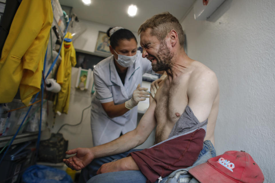 A homeless man reacts as he gets a shot of the one-dose Sputnik Light vaccine at a mobile vaccination station in St. Petersburg, Russia, Wednesday, Aug. 11, 2021. Russia has faced a surge in new infections blamed on the growing prevalence of the more contagious delta variant and low vaccine uptake. (AP Photo/Elena Ignatyeva)