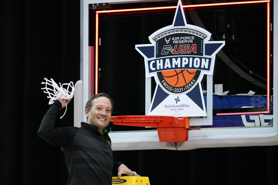 North Texas head coach Grant McCasland celebrates as he cuts down the net after the championship game against Western Kentucky in the NCAA Conference USA men's basketball tournament Saturday, March 13, 2021, in Frisco, Texas. North Texas won 61-57 in overtime. (AP Photo/Tony Gutierrez)