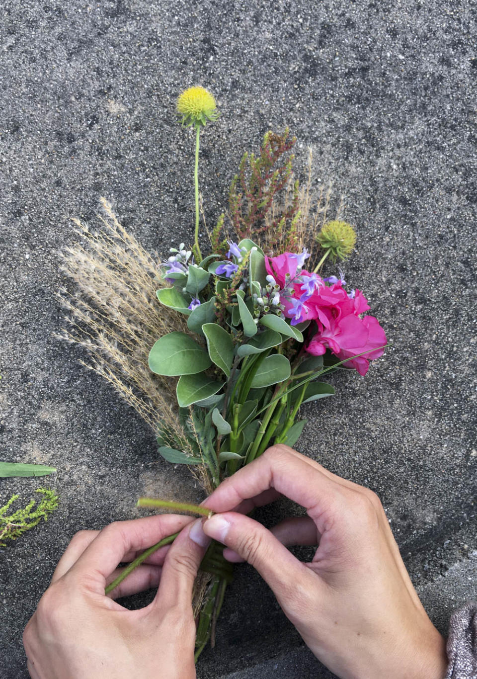 強妮就地取材將野花野草編織成一束捧花，送給東莒國小幼兒園的畢業生林庭妍。強妮喜歡使用自然的植物和大地材料作為創作素材。   圖：張良一/攝