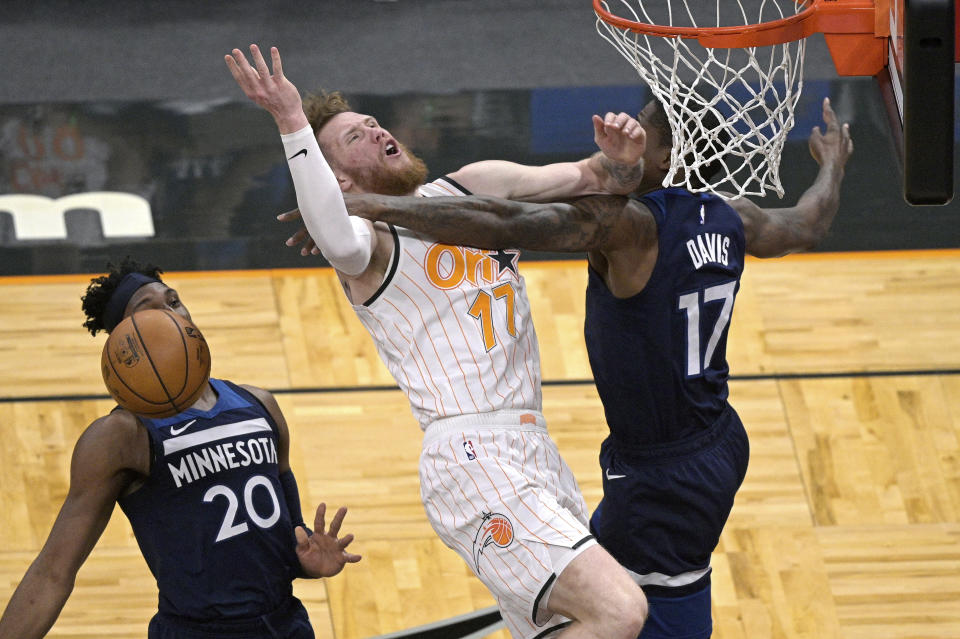 Orlando Magic forward Ignas Brazdeikis (17) is fouled by Minnesota Timberwolves center Ed Davis, right, as forward Josh Okogie (20) watches during the second half of an NBA basketball game Sunday, May 9, 2021, in Orlando, Fla. (AP Photo/Phelan M. Ebenhack)