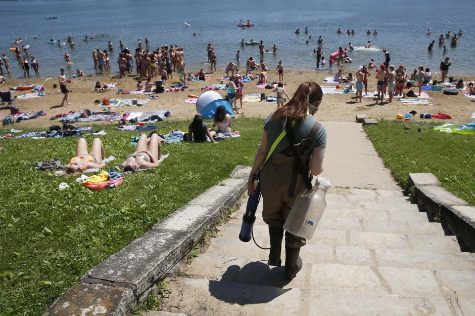 State water quality technician Elizabeth Heckman walks June 2 to the beach for weekly water sampling at Lake Macbride in Solon. The Iowa Department of Natural Resources reported 118 swim advisories at the 39 state park beaches after conducting weekly tests like this from Memorial Day weekend through Labor Day.