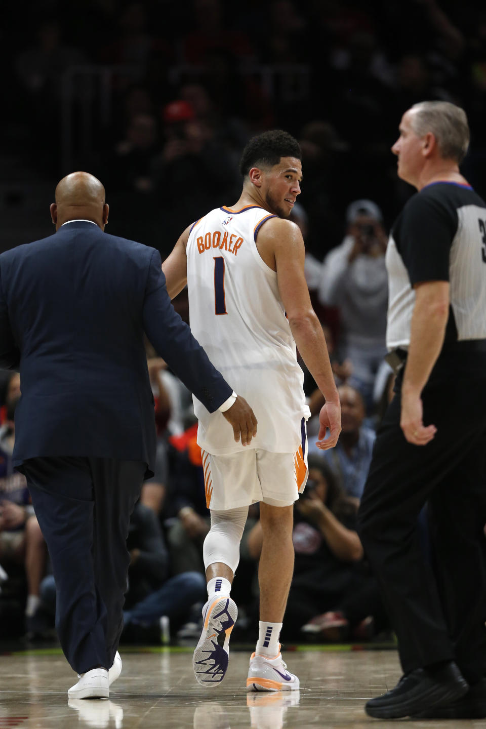 Phoenix Suns guard Devin Booker (1) looks back at an official as he leaves the court after being ejected in the second half of an NBA basketball game against the Atlanta Hawks Tuesday, Jan. 14, 2020, in Atlanta. The Hawks won 123-110. (AP Photo/John Bazemore)