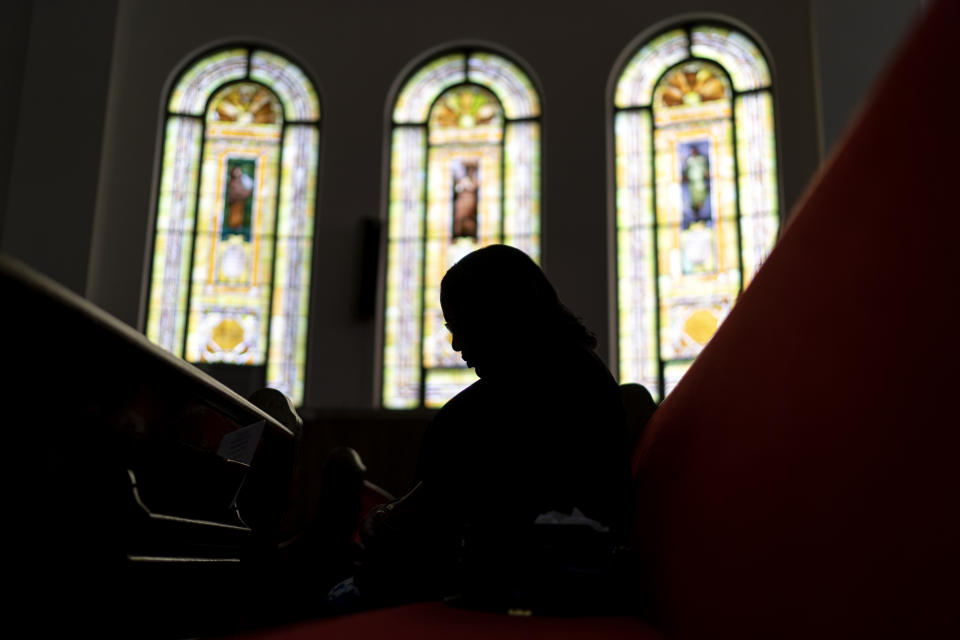 A parishioner prays during a service at Trinity Baptist Church Sunday, Aug. 20, 2023, in Niagara Falls, N.Y. A 24-year-old man was shot to death in the street two blocks from the chapel in January. (AP Photo/David Goldman)