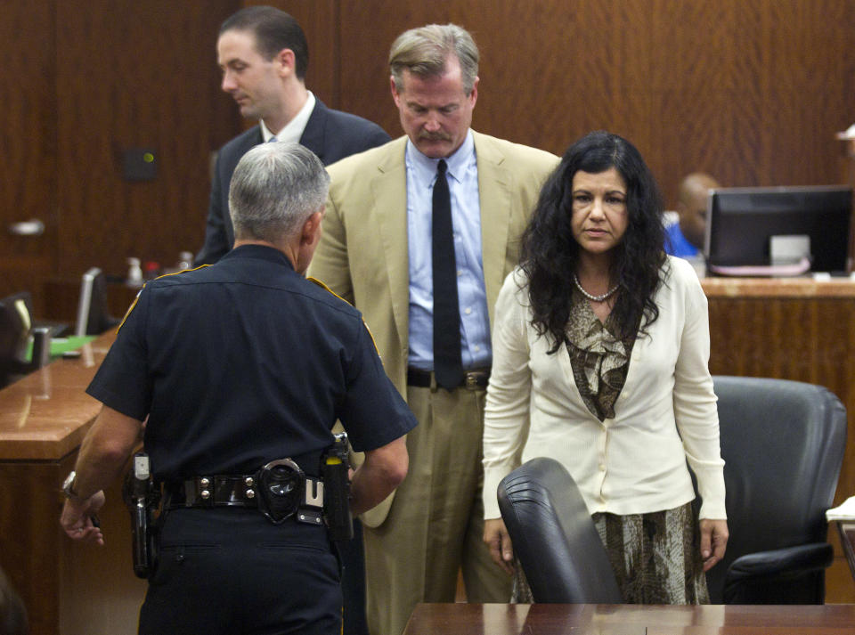 Ana Trujillo, right, stands just before being taken from the courtroom and into custody, after being found guilty of murder, on Tuesday, April 8, 2014, in Houston. Trujillo, 45, was found guilty of fatally stabbing her boyfriend with the stiletto heel of her shoe, hitting him at least 25 times in the face. (AP Photo/Houston Chronicle, Brett Coomer)