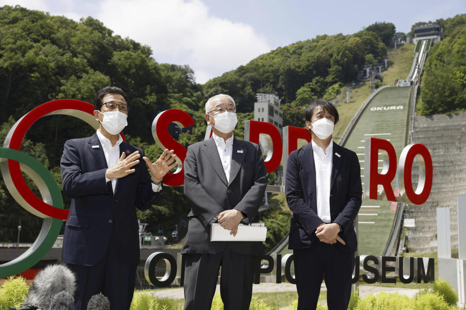 Sapporo Mayor Katsuhiro Akimoto, left, speaks during a news conference at a proposed site for the Olympics ski jump in Sapporo, northern Japan, on July 30, 2022. Sapporo's bid for the 2030 Winter Olympics has been slowed, but not stopped, by fallout from the still-developing corruption scandal around the 2020 Tokyo Games. (Yuta Omori/Kyodo News via AP)