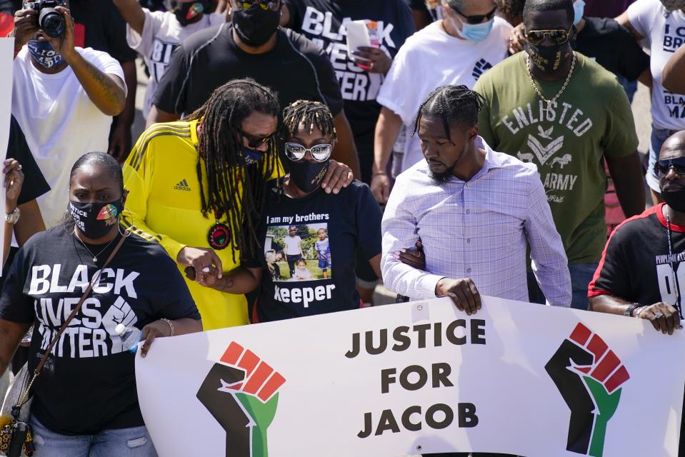 Jacob Blake's sister Letetra Widman, center, and uncle Justin Blake, left, march at a rally for Jacob Blake Saturday, Aug. 29, 2020, in Kenosha, Wis. (AP Photo/Morry Gash)