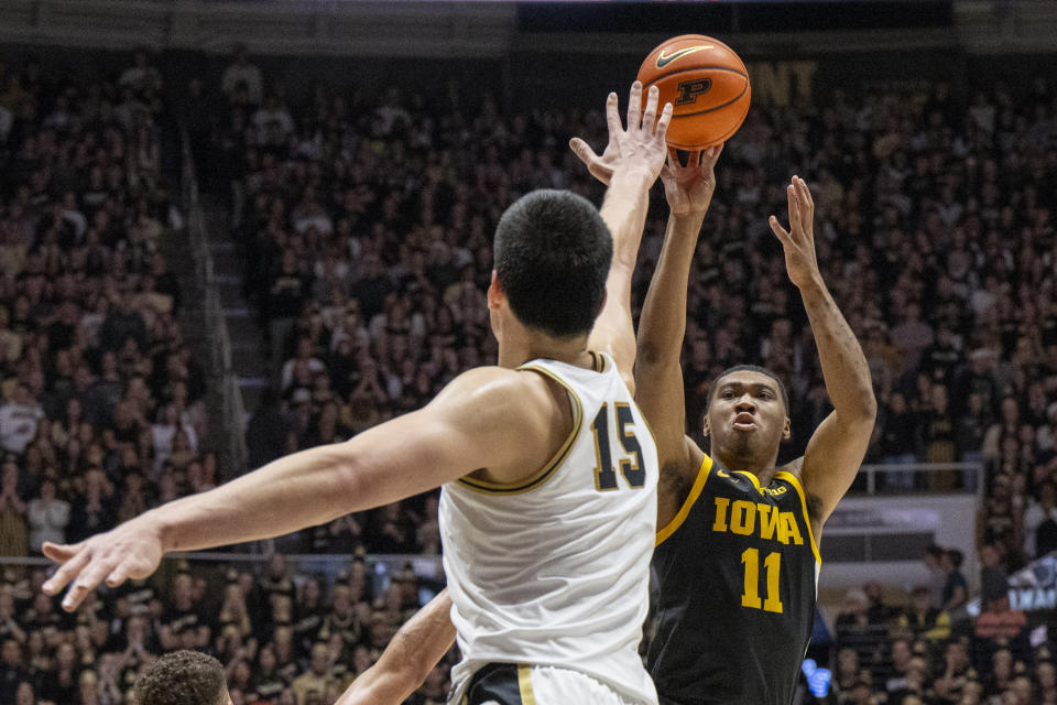 Iowa guard Tony Perkins (11) shoots over the defense of Purdue center Zach Edey (15) during the first half of an NCAA college basketball game, Monday, Dec. 4, 2023, in West Lafayette, Ind. (AP Photo/Doug McSchooler)