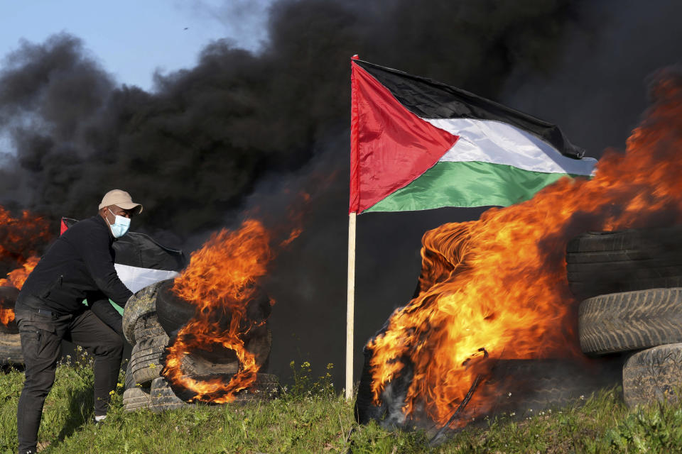 Demonstrator burns tires during a protest against Israeli military raid in the West Bank city of Nablus, along the border fence with Israel, in east of Gaza City, Wednesday, Feb. 22, 2023. Palestinian officials say several Palestinians have been killed and over a hundred were wounded during a rare daytime Israeli army arrest raid in the occupied West Bank. The Palestinian Health Ministry says a 72-year-old man was among the dead. The raid took place on Wednesday in the city of Nablus, a scene of frequent military activity. (AP Photo/Adel Hana)