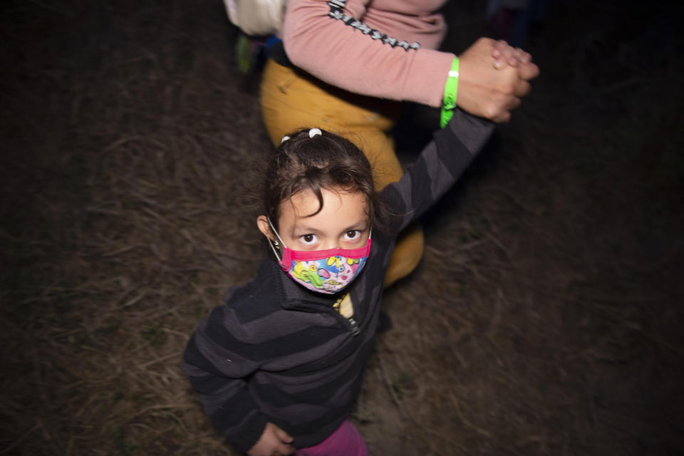 Migrants families, mostly from Central American countries, walk through the brush after being smuggled across the Rio Grande river in Roma, Texas, Wednesday, March 24, 2021. (AP Photo/Dario Lopez-Mills)