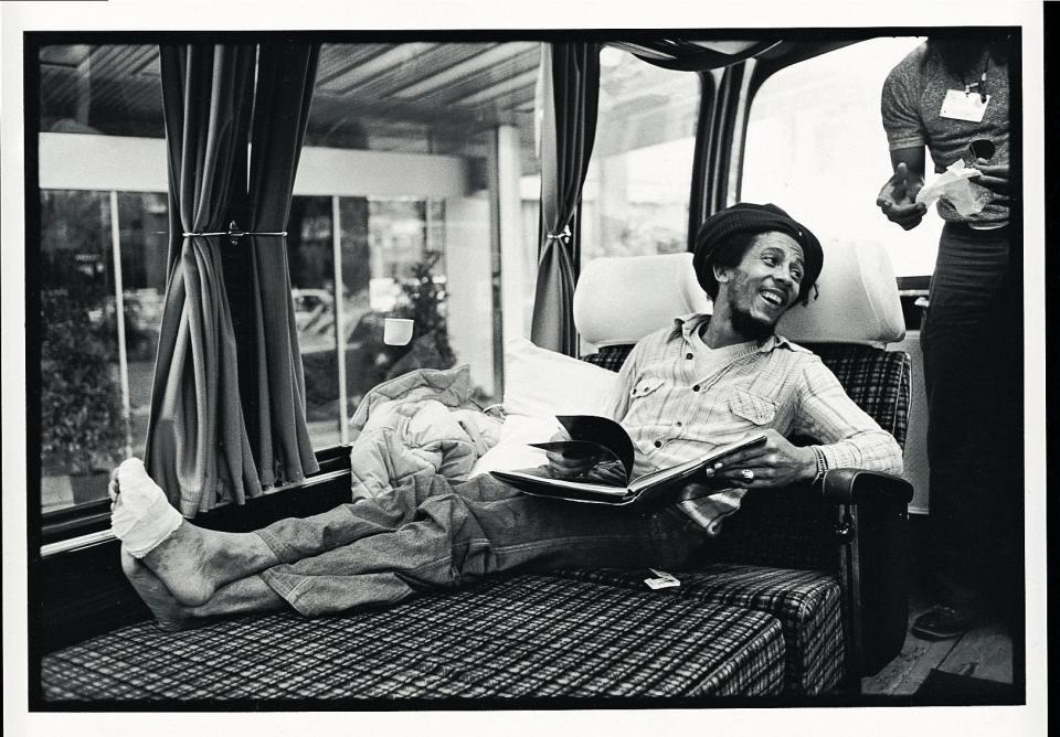 Bob Marley smiles on his tour bus while turning a bandaged toe, a soccer injury that eventually would lead to the discovery of cancer that in 1981 would take the musician's life. The photo is one of many intimate shots in "Rebel Music: Bob Marley & Roots Reggae."