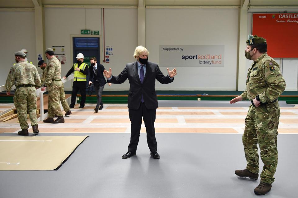 Britain's Prime Minister Boris Johnson meets troops as they set up a vaccination centre in the Castlemilk district in Glasgow, Scotland on January 28, 2021, during a COVID-19 related visit to the country. - Prime Minister Boris Johnson headed to Scotland on Thursday to praise the United Kingdom's collective response to coronavirus, in a bid to counter record support for independence. (Photo by Jeff J Mitchell / POOL / AFP) (Photo by JEFF J MITCHELL/POOL/AFP via Getty Images)