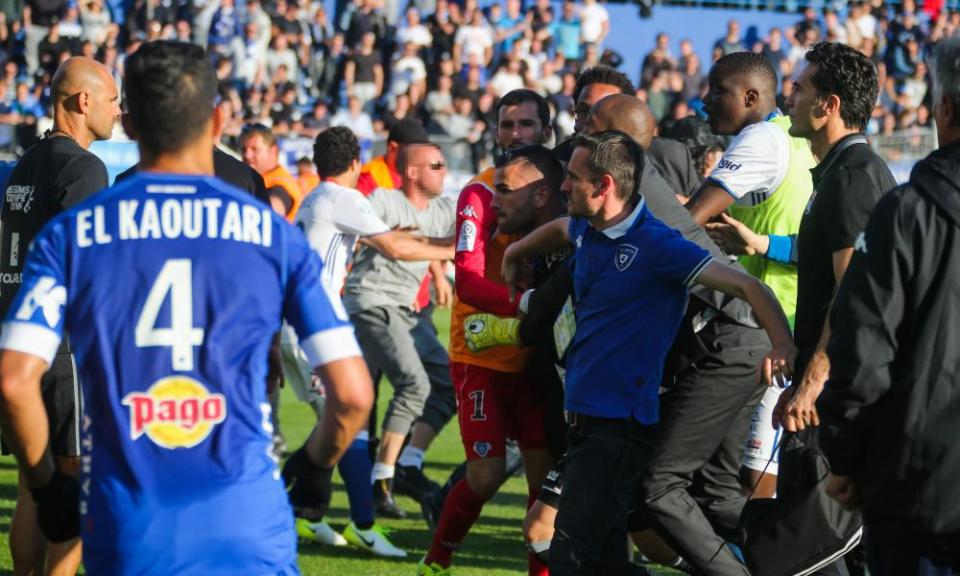 The Lyon goalkeeper Anthony Lopes is held back during an altercation with Bastia fans during the teams’ subsequently abandoned Ligue 1 match.