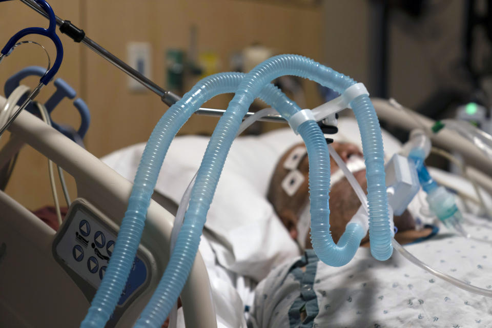 FILE - In this Nov. 19, 2002 file photo, ventilator tubes are attached a COVID-19 patient at Providence Holy Cross Medical Center in the Mission Hills section of Los Angeles. California reported more than 50,000 new coronavirus cases and 293 deaths on Wednesday, Dec. 16, 2020, setting new daily records as hospitals struggled to keep up with the surge. Southern California and the state's Central Valley — regions that together include 23 counties and most of the state's nearly 40 million residents — had exhausted their regular supply of intensive care beds and many hospitals were tapping into their "surge" capacity. (AP Photo/Jae C. Hong, File)