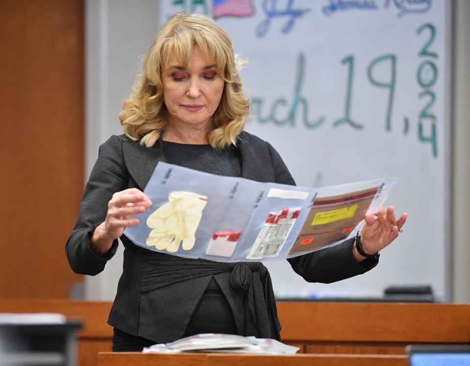 Assistant State Attorney Karen Fraivillig looks at evidence collected from the vehicle of Tyren Kinard. Juan Salazar-Diaz is on trial for the September 2018 murder of Kinard in North Port.