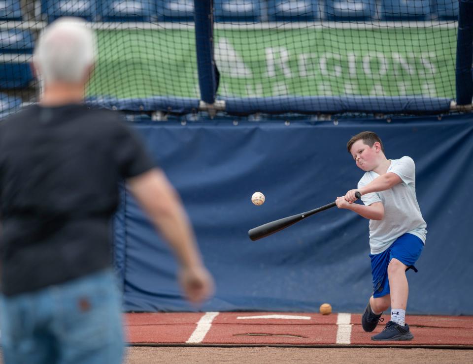 Hudson Furness, right, gets in some batting practice at Blue Wahoos Stadium in Pensacola on Monday. His mother, Amanda "Mandi" Furness, who has been battling lupus and multiple sclerosis, used her My Wish granted by Covenant Care to see her 10-year-old son play baseball at the stadium.