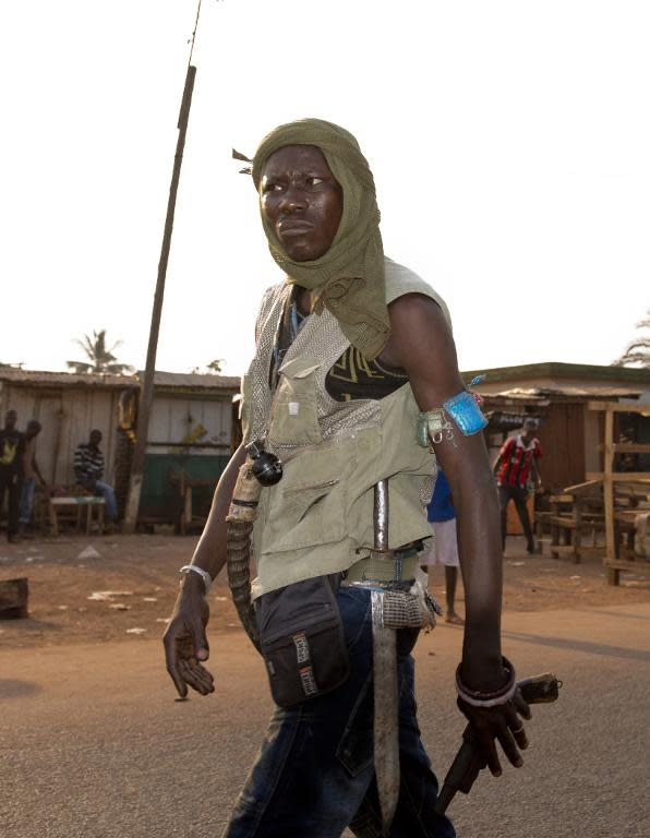 An anti-Balaka militiaman walks in a street of the Gobongo neighborhood in Bangui on December 23, 2013