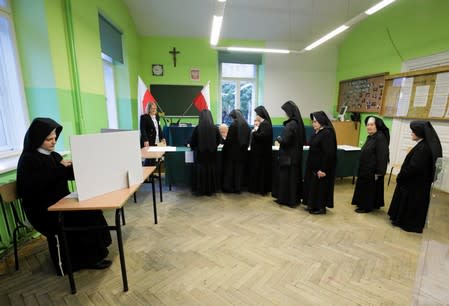 Nuns line up to receive their ballots during parliamentary election at a polling station in Krakow